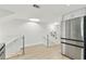 Bright hallway with stainless steel refrigerator, glass railing staircase, and skylight at 9812 Indian Key Trl # 84, Seminole, FL 33776