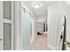 Hallway featuring carpeted floors, a sliding glass door to a bedroom, and a decorative mirror at 9812 Indian Key Trl # 84, Seminole, FL 33776