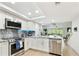 Bright, remodeled kitchen features stainless steel appliances, sleek countertops, and a seamless view into the living area at 9812 Indian Key Trl # 84, Seminole, FL 33776