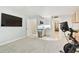 Bright living area adjacent to a modern kitchen, featuring fitness equipment and comfortable seating at 9812 Indian Key Trl # 84, Seminole, FL 33776