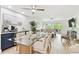 Open-concept living room features a glass table, coffee bar, ceiling fans, and balcony access at 9812 Indian Key Trl # 84, Seminole, FL 33776