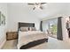Bedroom features a tufted headboard, neutral decor, and sliding glass doors to a balcony at 9812 Indian Key Trl # 84, Seminole, FL 33776