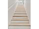 Bright stairway featuring light wood treads and white risers leading to the upper level of the home at 9812 Indian Key Trl # 84, Seminole, FL 33776