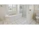 Bright bathroom with a large soaking tub, glass-enclosed shower, and natural light at 9912 Chris Craft Ct, Tampa, FL 33615