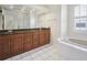 Bathroom featuring double vanity, soaking tub, walk-in shower, and modern fixtures at 9912 Chris Craft Ct, Tampa, FL 33615
