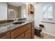 Well-lit bathroom showcasing a granite countertop, dark wood cabinets, and shuttered windows at 9912 Chris Craft Ct, Tampa, FL 33615