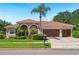 Charming single-story home with a clay tile roof and a well-manicured front lawn at 9912 Chris Craft Ct, Tampa, FL 33615