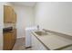 Functional laundry room with storage cabinets, a utility sink, and modern washer and dryer at 9912 Chris Craft Ct, Tampa, FL 33615