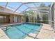 Sparkling screened-in pool featuring brick paver deck and a tranquil backyard setting at 9912 Chris Craft Ct, Tampa, FL 33615
