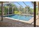 Inviting screened-in pool surrounded by brick pavers and lush tropical foliage at 9912 Chris Craft Ct, Tampa, FL 33615