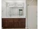 Bathroom featuring double vanity, large mirror, shower stall and neutral colored walls at 10326 Boggy Moss Dr, Riverview, FL 33578