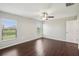 This bright bedroom has wood floors, a ceiling fan, and windows for ample sunlight at 10326 Boggy Moss Dr, Riverview, FL 33578