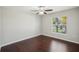This bright bedroom has wood floors, a ceiling fan, and a window for ample sunlight at 10326 Boggy Moss Dr, Riverview, FL 33578