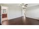 This bright bedroom has wood floors, a ceiling fan, and doorway leading to the bathroom at 10326 Boggy Moss Dr, Riverview, FL 33578