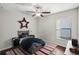 Cozy bedroom with a ceiling fan, window and hardwood floors at 10326 Boggy Moss Dr, Riverview, FL 33578