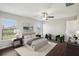Staged bedroom showcasing a well-lit room with a bed, chairs, hardwood floors and windows at 10326 Boggy Moss Dr, Riverview, FL 33578