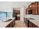 Spacious kitchen with black appliances, a center island with sink and dark wood cabinets at 10326 Boggy Moss Dr, Riverview, FL 33578
