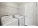 Functional laundry room featuring a washer, dryer, and wire shelving at 10326 Boggy Moss Dr, Riverview, FL 33578