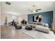 Staged living room with a modern sofa, dining set, and blue accent wall at 10326 Boggy Moss Dr, Riverview, FL 33578