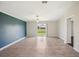 Spacious living room with tile flooring, ceiling fan, and sliding glass doors to the backyard at 10326 Boggy Moss Dr, Riverview, FL 33578