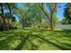 Expansive backyard with lush green lawn, mature trees, and a serene pond, offering a private outdoor oasis at 10406 N Boulevard, Tampa, FL 33612