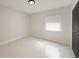 Clean bedroom with white walls, marble floors, a modern light fixture, and a black door creating a minimalist space at 10406 N Boulevard, Tampa, FL 33612
