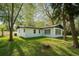 Beautifully landscaped home with a sprawling lawn, mature trees, a freshly painted exterior, and a private backyard at 10406 N Boulevard, Tampa, FL 33612