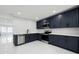 Modern kitchen features stainless steel appliances, quartz countertops, and stylish blue cabinetry at 10406 N Boulevard, Tampa, FL 33612