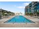 Image displays a bright blue outdoor pool with seating and partial building in the background on a sunny day at 1120 E Kennedy Blvd # 1127, Tampa, FL 33602
