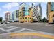 View of the colorful modern condo building with sidewalks and street traffic on a sunny day at 1120 E Kennedy Blvd # 1127, Tampa, FL 33602