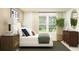Bright bedroom with a plush bed, bedside tables, and a large window with a view at 11746 Brae Way, Dade City, FL 33525