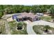 Single-story home with a screened-in pool, three-car garage, circular driveway and a spacious yard at 13110 Manistee Rd, Weeki Wachee, FL 34614
