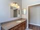 Granite countertop and a wooden vanity in a bathroom with a framed mirror at 13110 Manistee Rd, Weeki Wachee, FL 34614