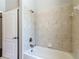 Bathroom with a tiled shower and a white tub at 13110 Manistee Rd, Weeki Wachee, FL 34614