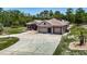 Single-story home with a three-car garage and long driveway in a tree-lined neighborhood at 13110 Manistee Rd, Weeki Wachee, FL 34614