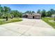 Single-story home with a three-car garage, and circular driveway on a well-maintained, grassy lot at 13110 Manistee Rd, Weeki Wachee, FL 34614