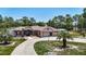 Inviting single-story home featuring a three-car garage, long driveway, and nicely landscaped grounds at 13110 Manistee Rd, Weeki Wachee, FL 34614