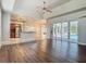 Open-concept living room features hardwood flooring, access to the kitchen and view of the screened-in pool at 13110 Manistee Rd, Weeki Wachee, FL 34614
