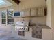 Outdoor kitchen features a built-in grill, sink, and storage, perfect for al fresco dining at 13110 Manistee Rd, Weeki Wachee, FL 34614