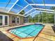Relaxing screened-in pool with blue tile, brick trim, and an outdoor tiled patio at 13110 Manistee Rd, Weeki Wachee, FL 34614
