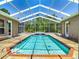 Enclosed pool with clear screening, brick trim, and lush green surroundings provides a tranquil retreat at 13110 Manistee Rd, Weeki Wachee, FL 34614