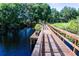 Community dock with built-in bench seating overlooks serene water, offering a relaxing lakeside retreat at 14245 Damselfly Dr, Tampa, FL 33625