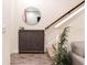 Charming entryway featuring wood-look tile, hall tree, round mirror, and staircase at 14245 Damselfly Dr, Tampa, FL 33625