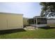 Yellow house exterior leading to a screen-enclosed lanai and manicured grassy backyard area at 1444 Eastfield Dr, Clearwater, FL 33764
