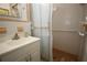 Well-lit bathroom with a shower featuring safety bars and a white sink at 1444 Eastfield Dr, Clearwater, FL 33764