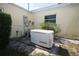 Exterior shot showcasing a generator and electrical equipment along the side of the yellow house at 1444 Eastfield Dr, Clearwater, FL 33764