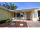 Inviting front porch area featuring brick flooring, decorative angel statue and blue shutters at 1444 Eastfield Dr, Clearwater, FL 33764