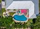 Aerial view of a home with a pool, patio, fire pit, and lush landscaping at 1503 Albemarle Ct, Dunedin, FL 34698