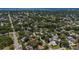 An aerial view of a lush neighborhood with mature trees and glimpses of the bay in the distance at 1503 Albemarle Ct, Dunedin, FL 34698