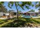 Backyard featuring a pool, outdoor seating, and lush landscaping at 1503 Albemarle Ct, Dunedin, FL 34698